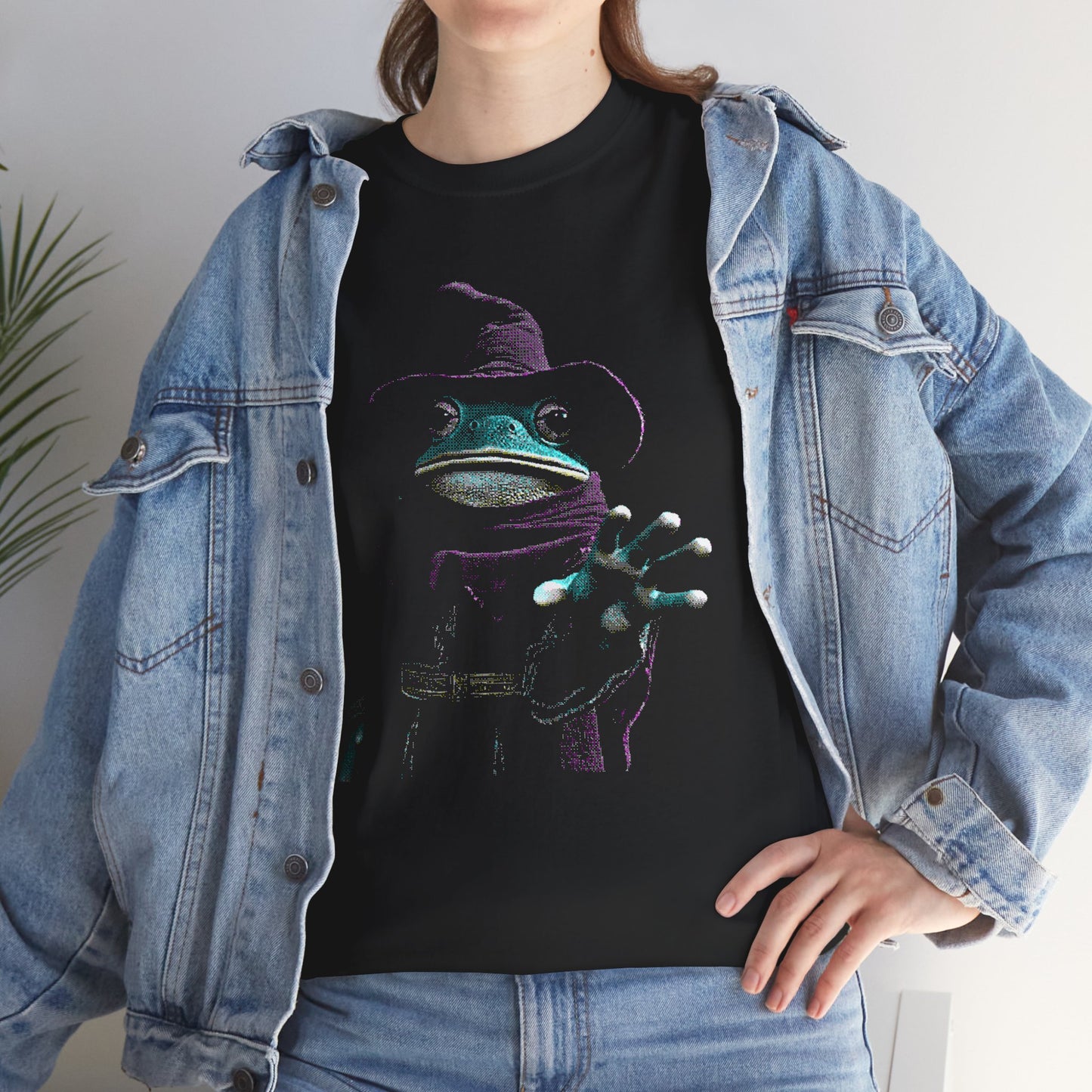 Woman wearing a Black T-Shirt of a dithered image of The Frog Mage reaching out towards the viewer