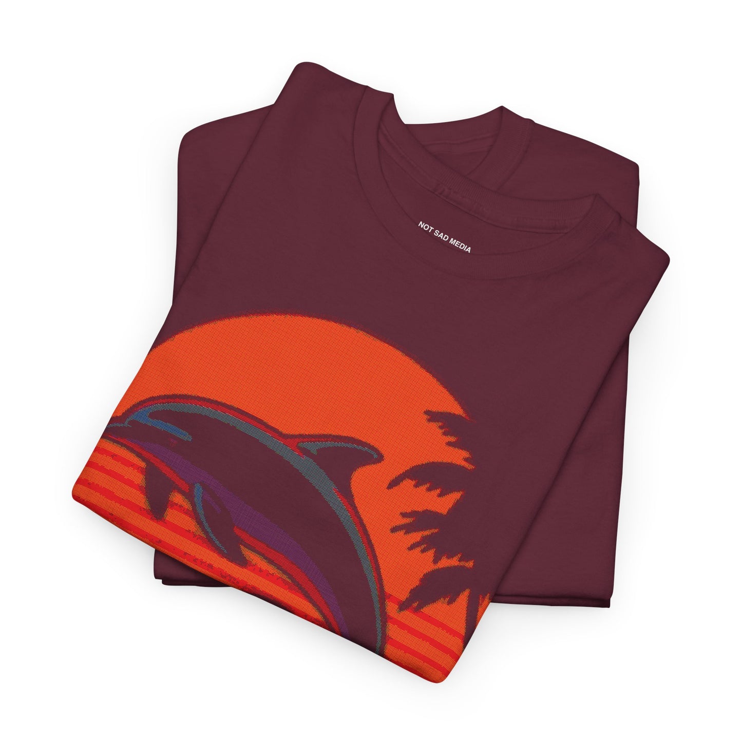 Folded Shirt with Dithered Retro Design of two dolphins jumping out of the water in front of a sunset with tropical palm trees on a maroon shirt