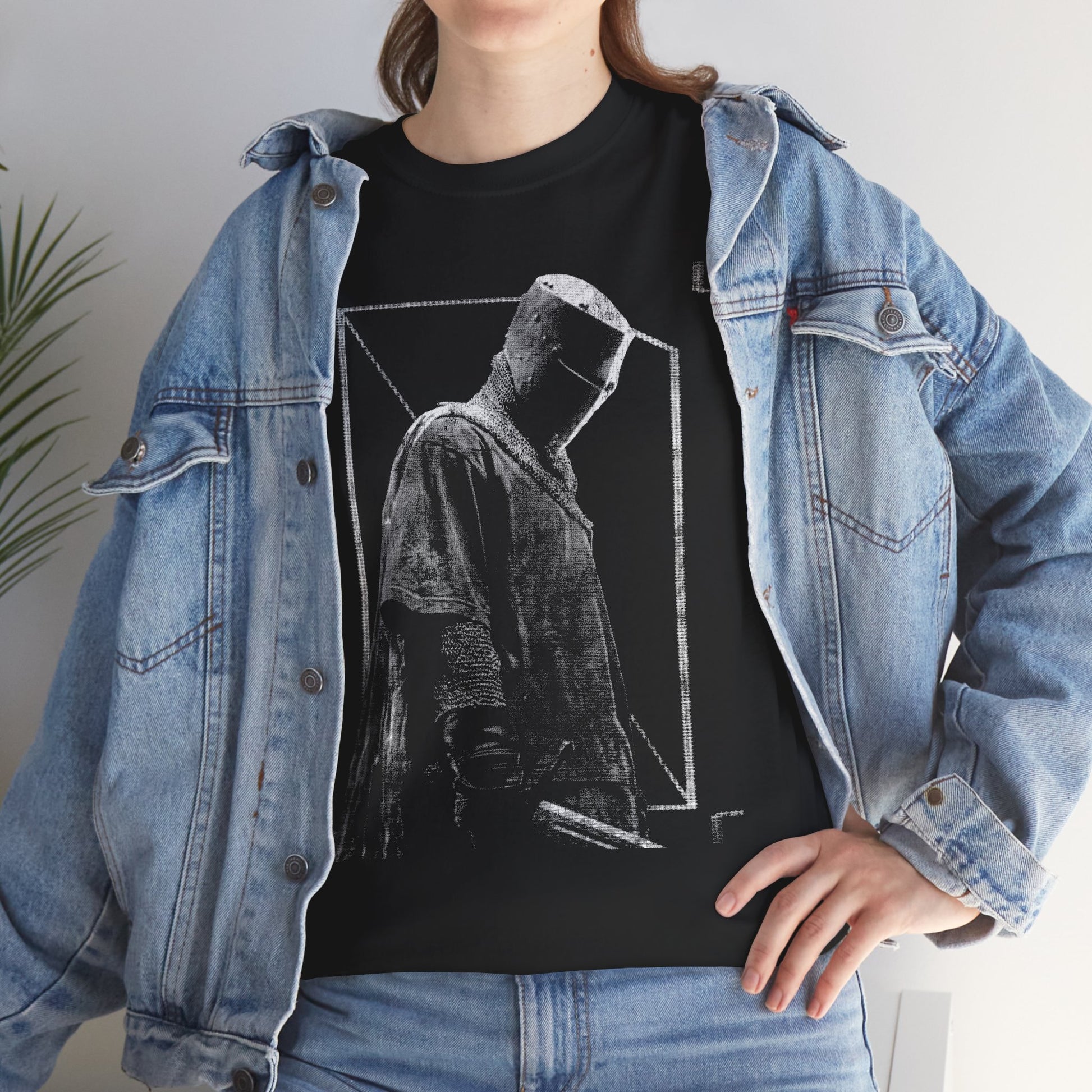 Person wearing a black t-shirt with a graphic design and a denim jacket.